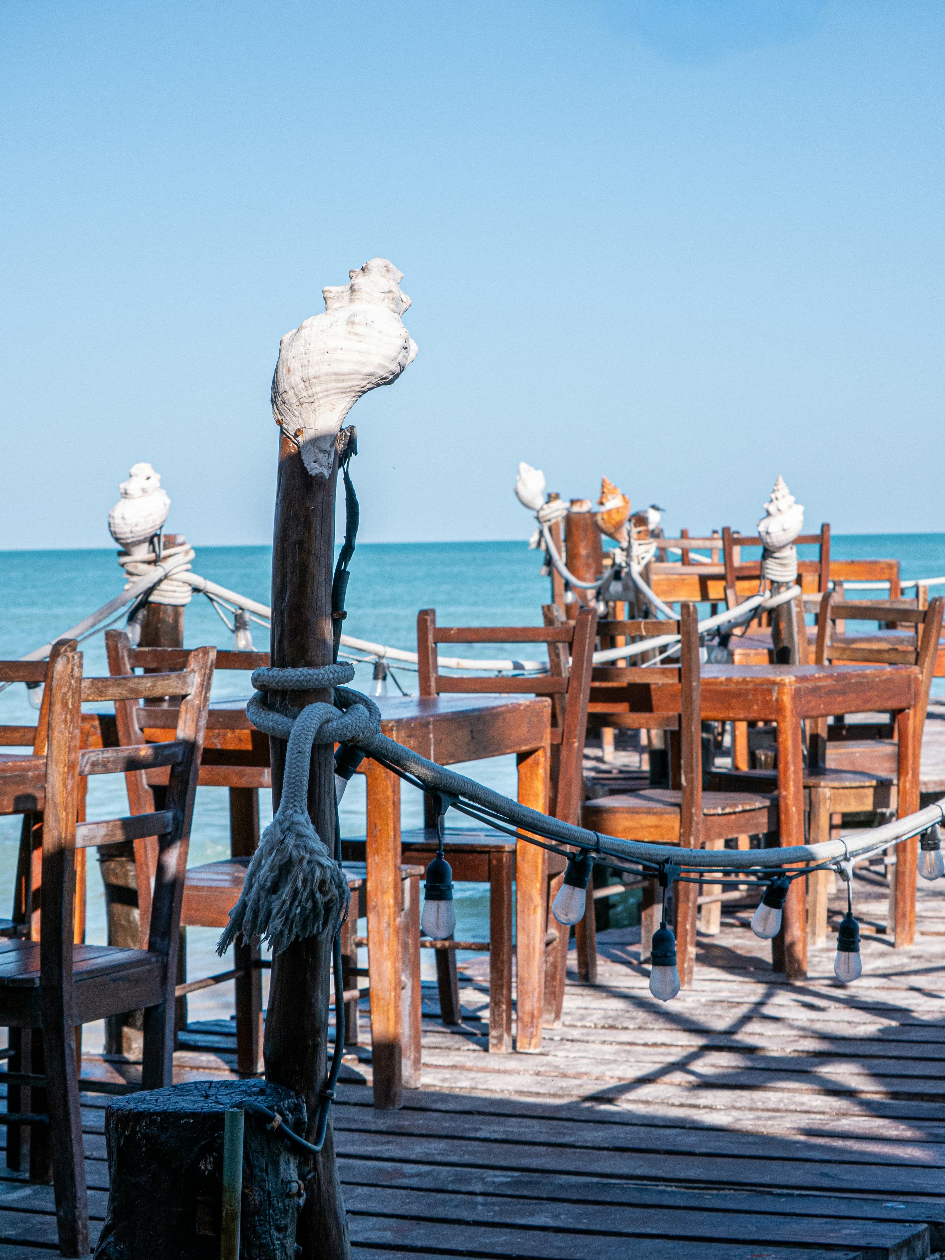 Tables set beside tall windows onto the water