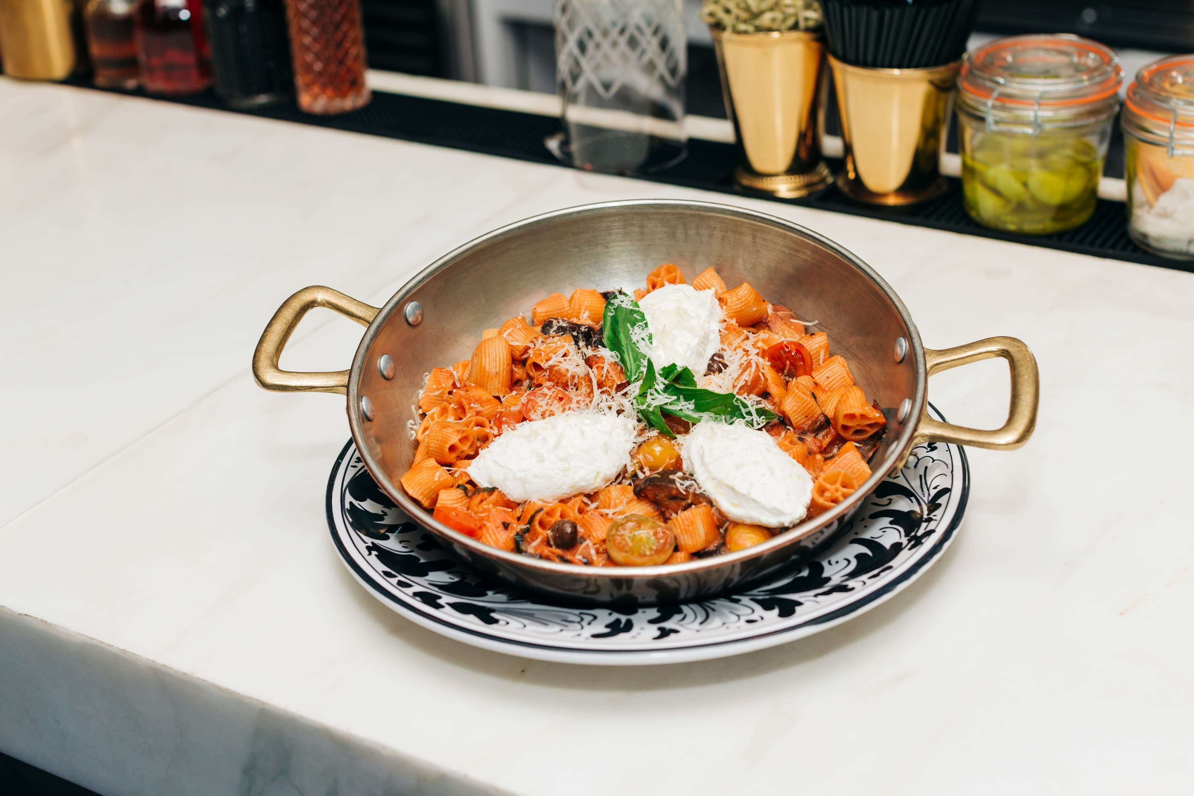 Bowls of pasta passed hand to hand