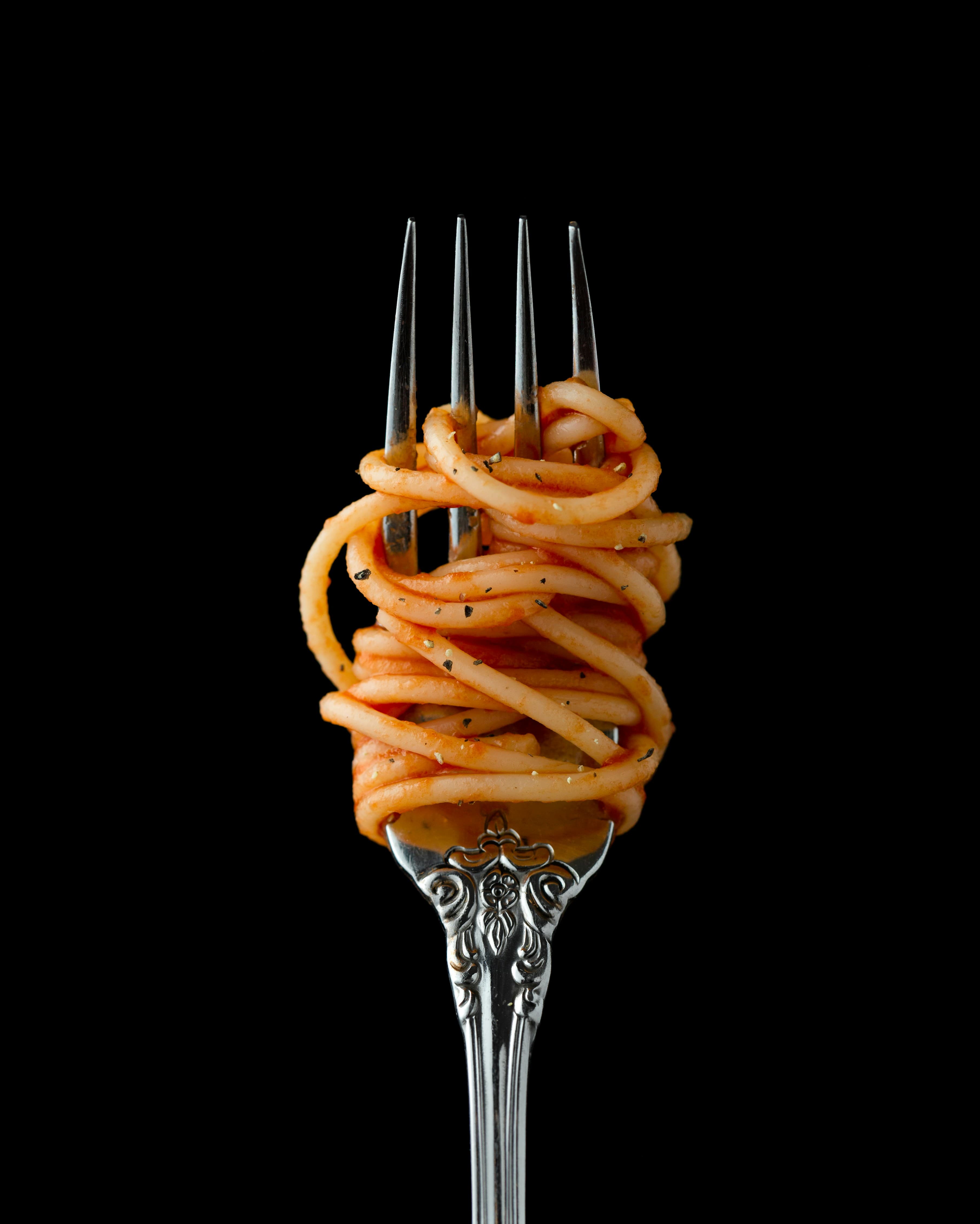 A plate of pasta under a single low light