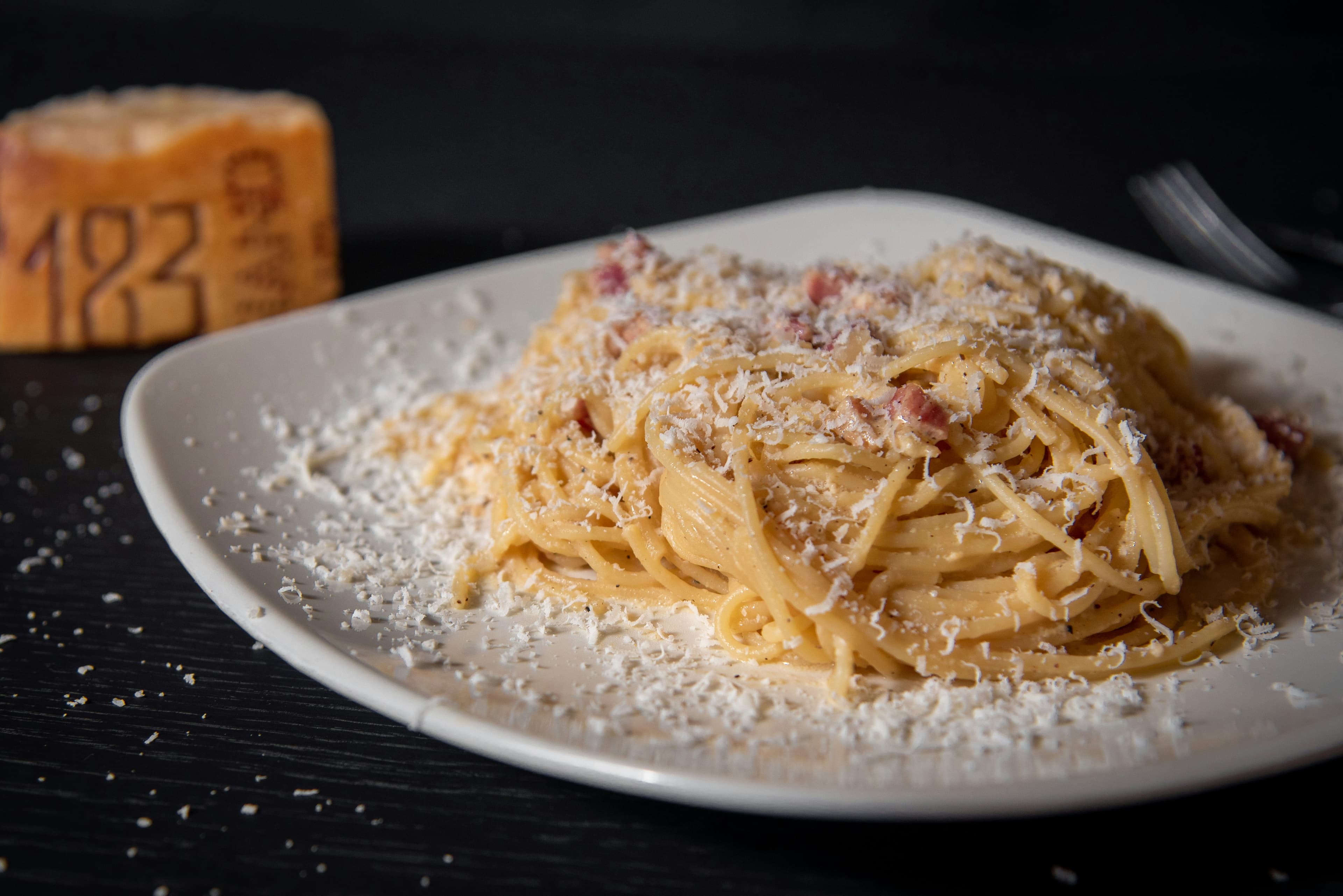 Pasta and herbs photographed against dark wood