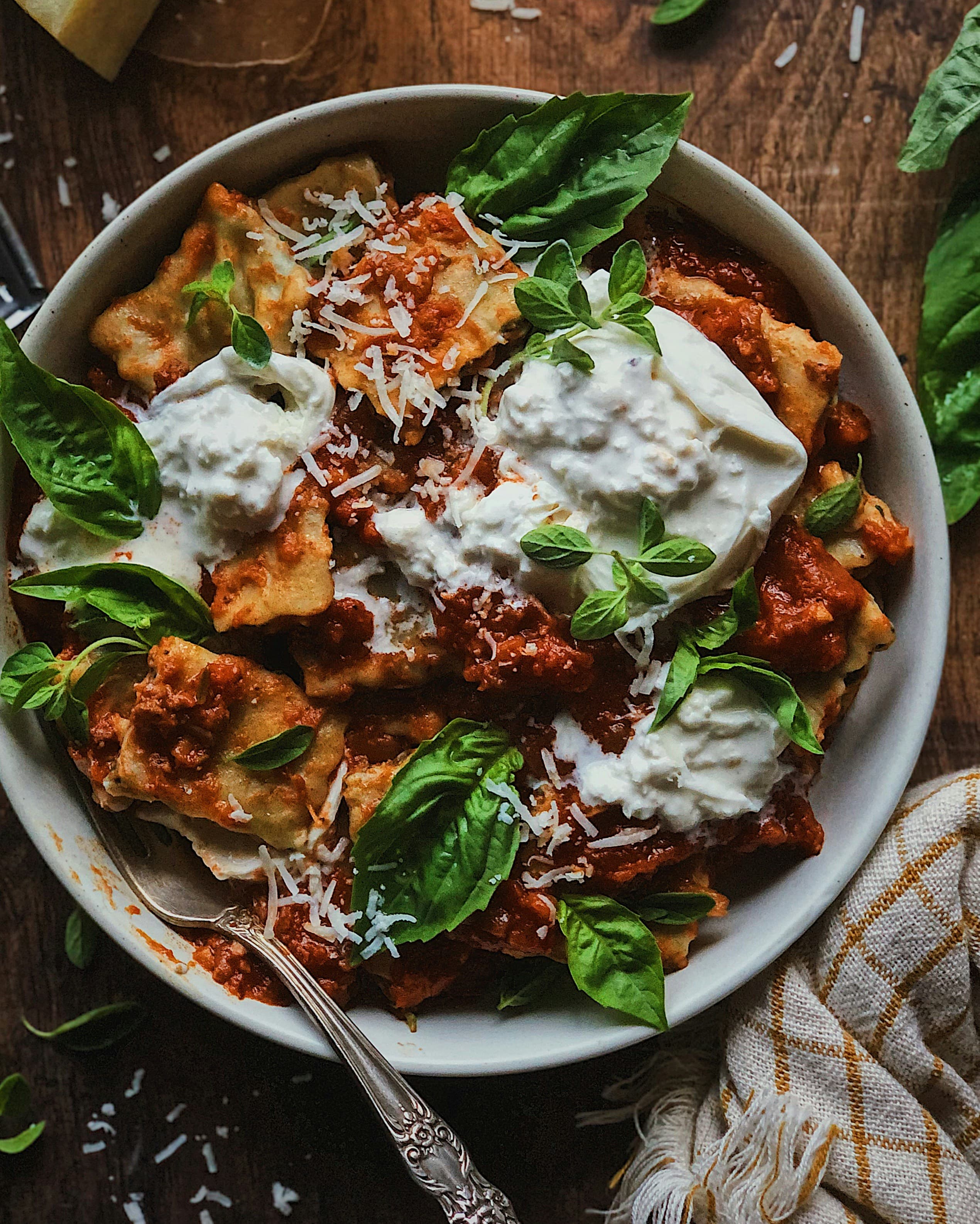 A shallow bowl of pasta at the edge of the light