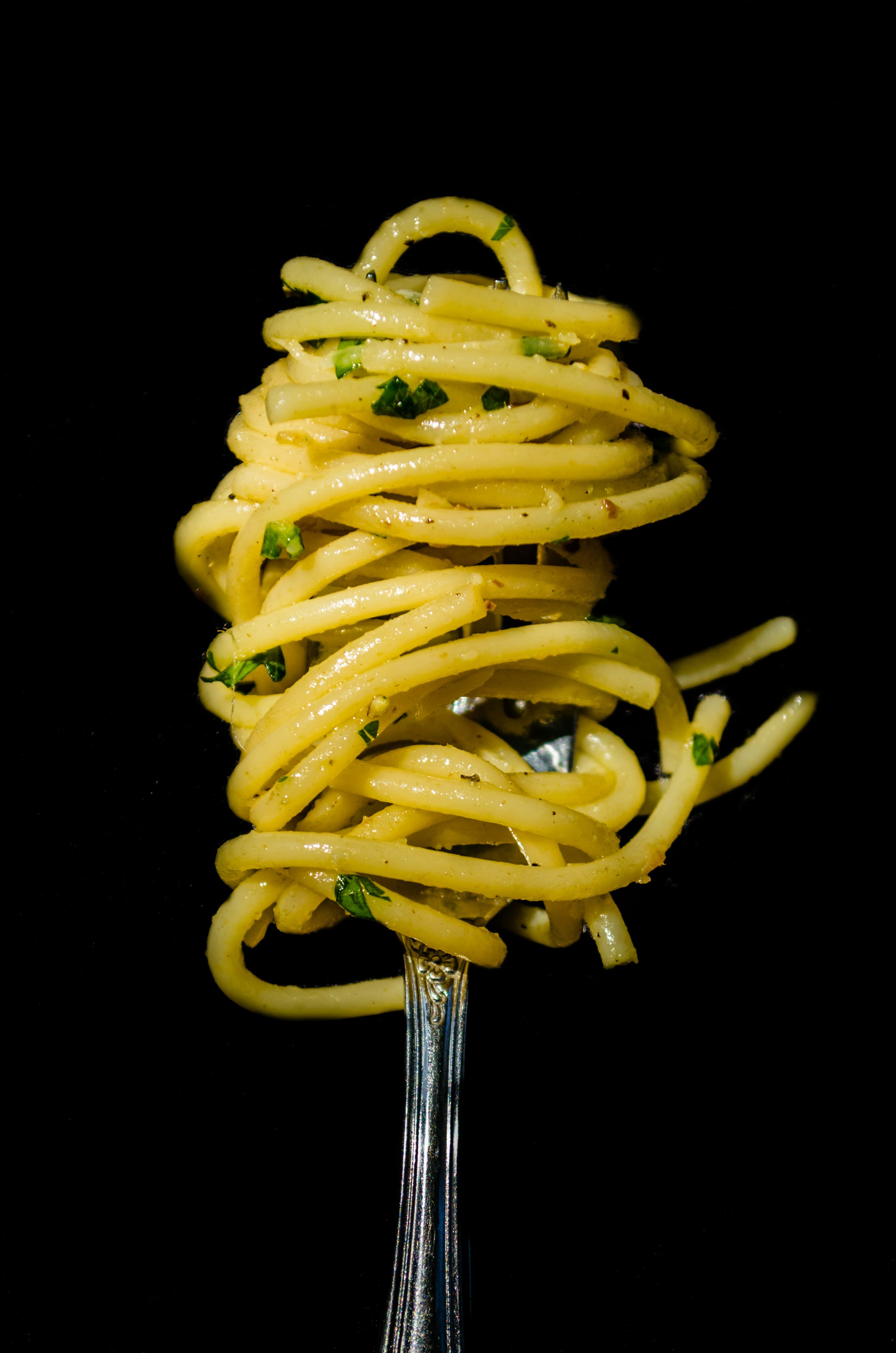 Fresh pasta held above a dark counter