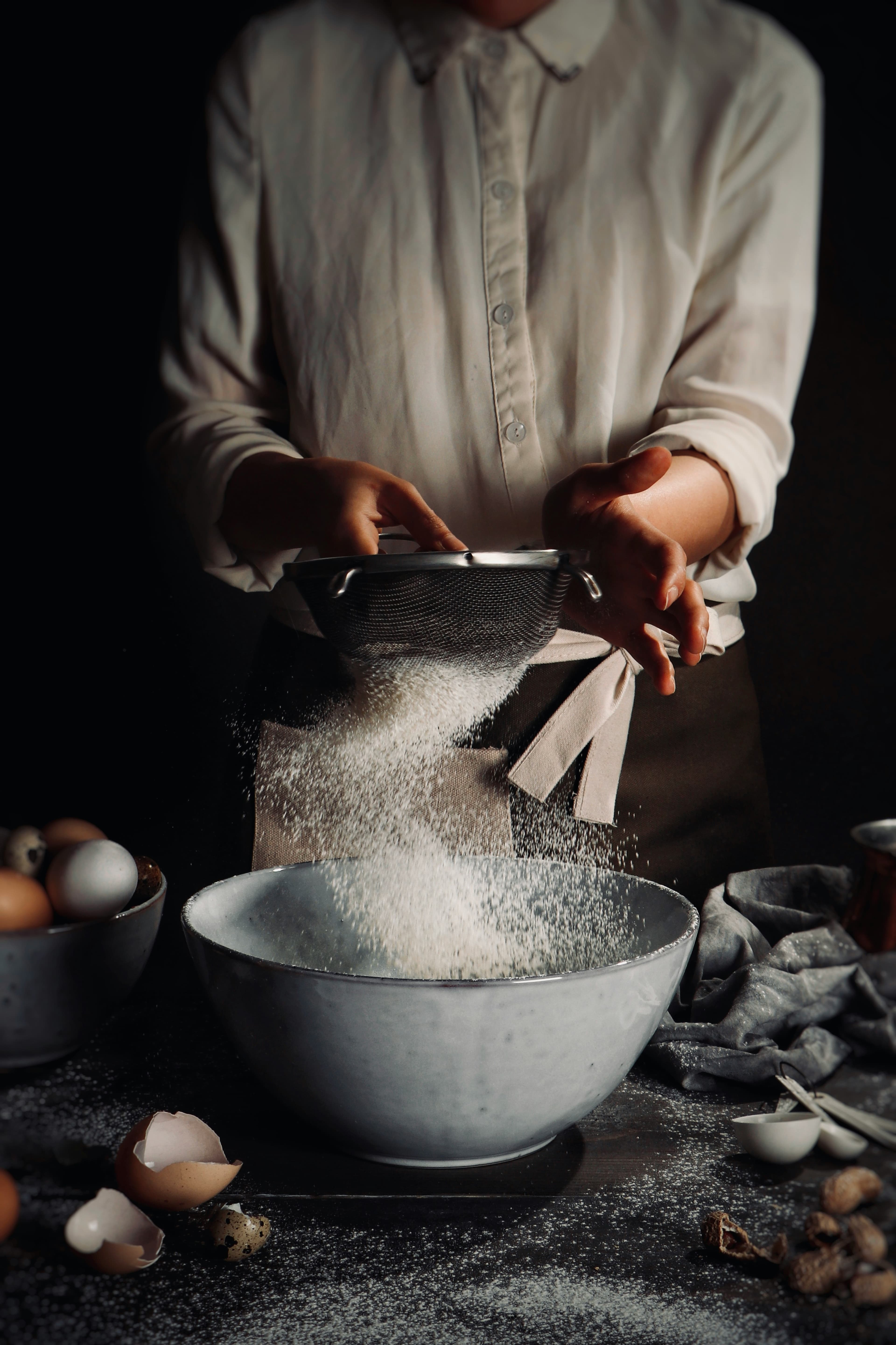 Flour scattered across a dark kitchen bench