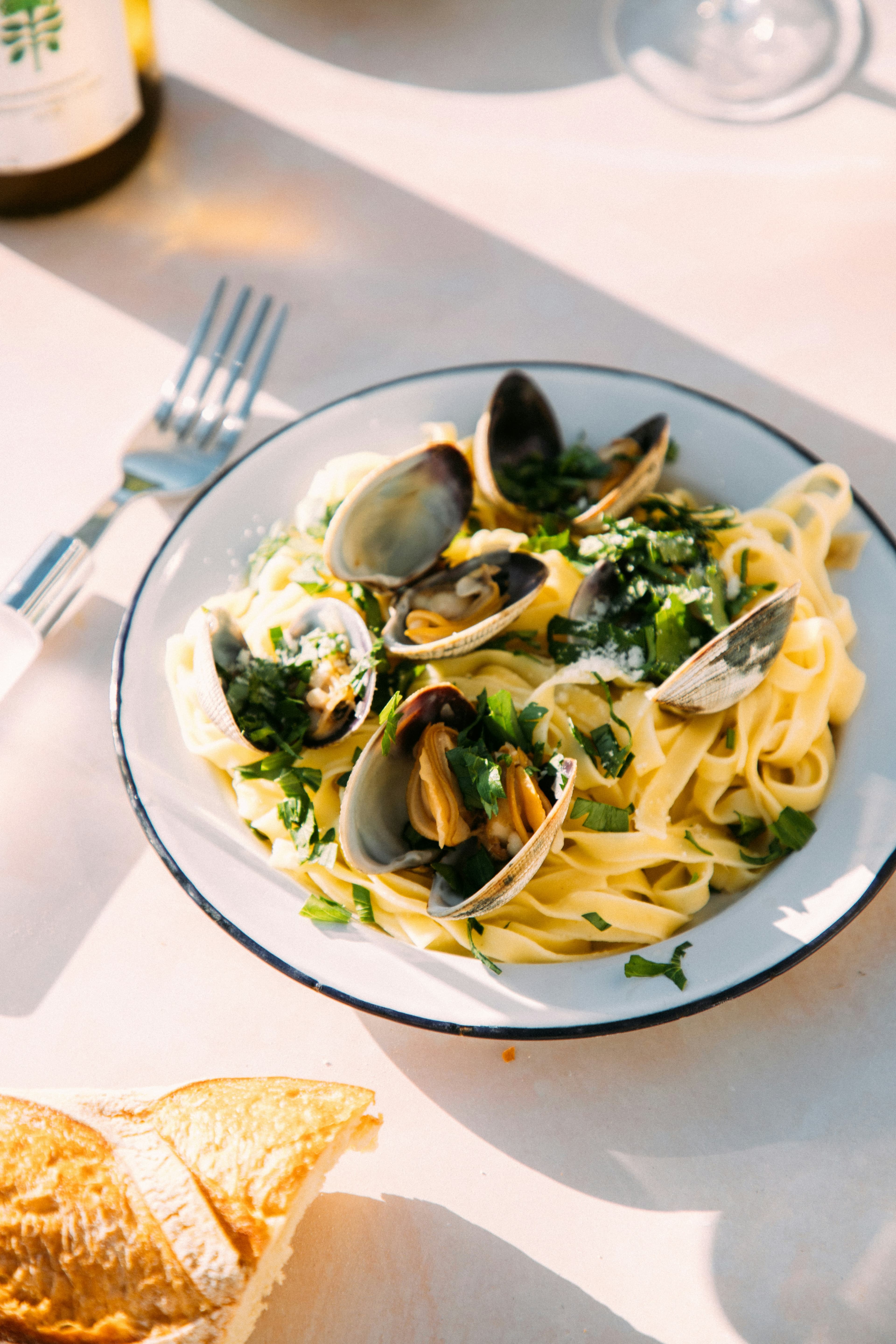 Shellfish arranged over pasta in a cast pan