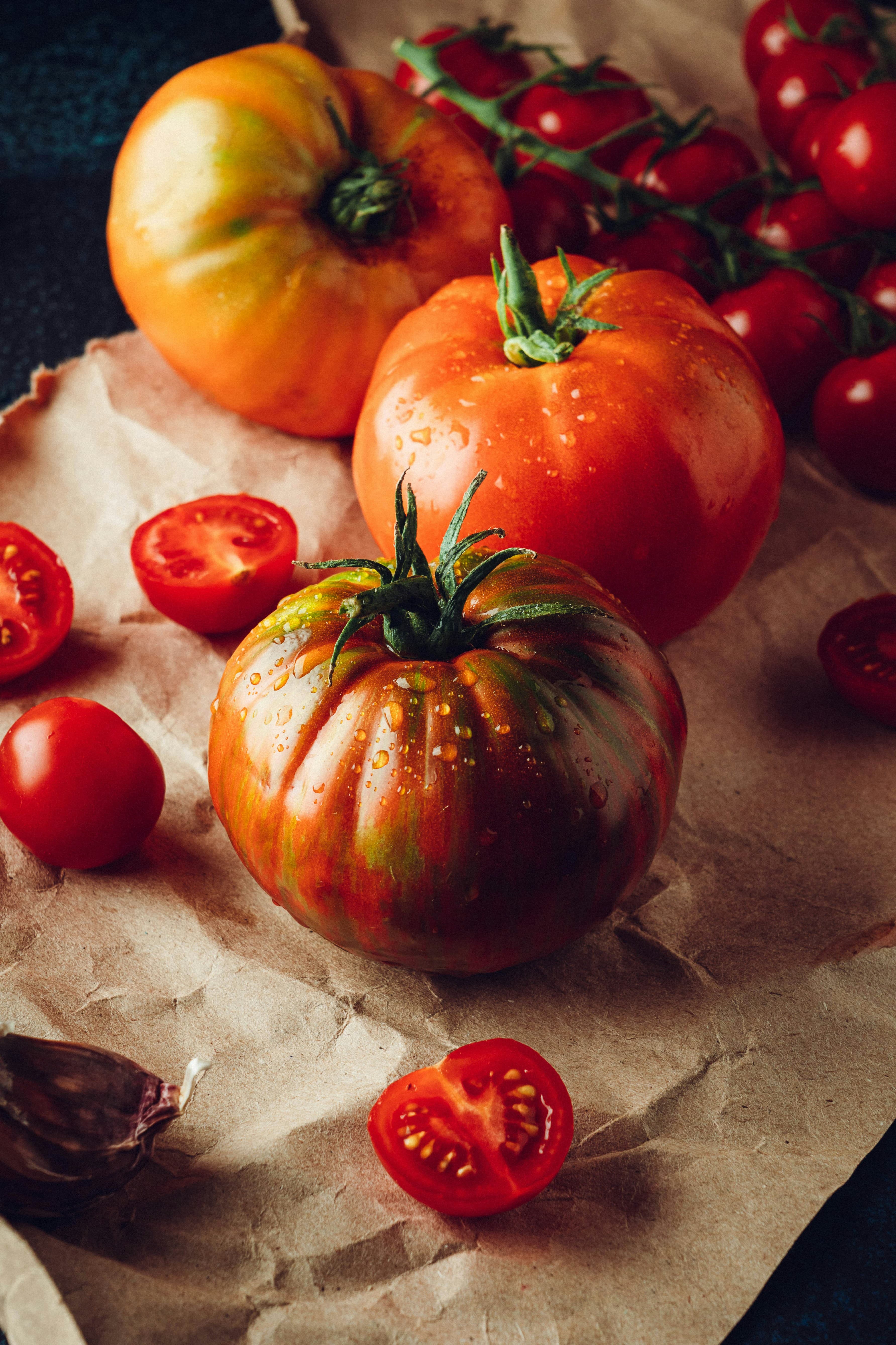 Tomatoes resting in a dark wooden crate