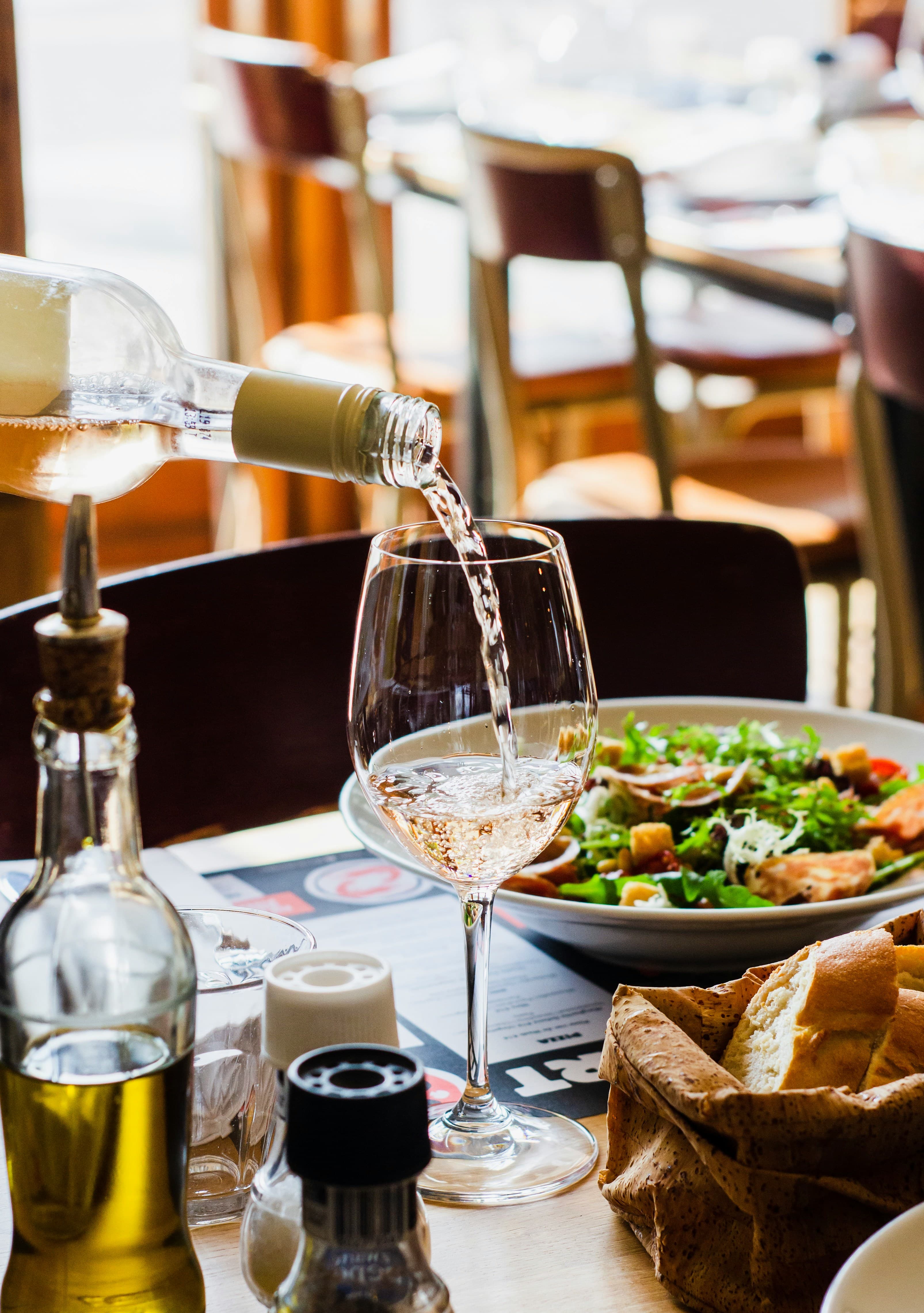 Wine poured at the table in warm restaurant light